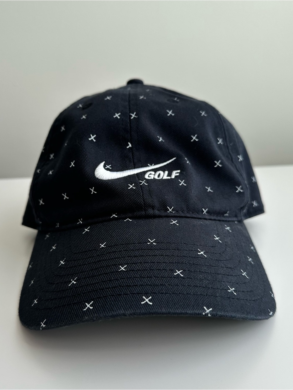 Nike Golf hate with small clubs crossing to form a X like pattern